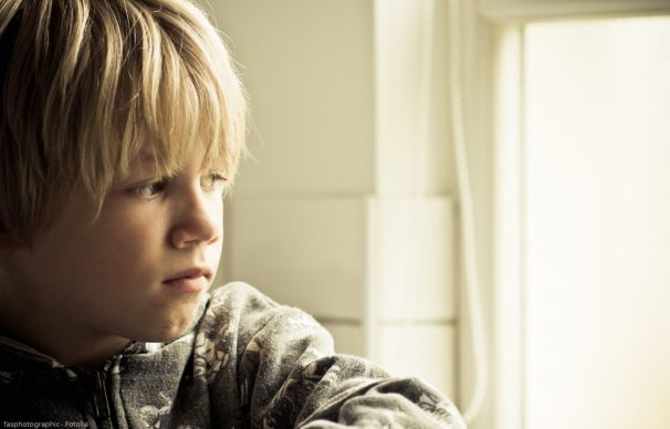 Grundschüler schaut traurig aus dem Fenster